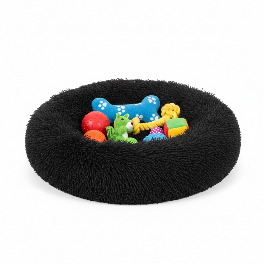 Black fluffy pet bed with colorful dog toys on a white background